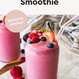 Kefir Smoothie topped with berries and served with a glass straw.