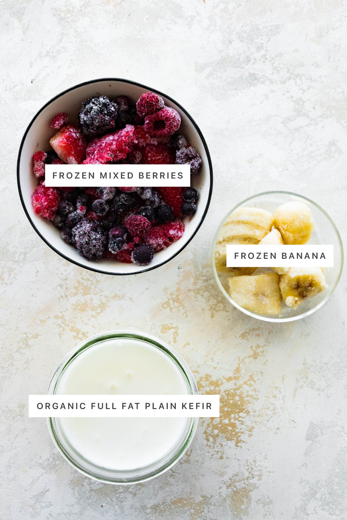 Ingredients measured out to make Kefir Smoothie: frozen mixed berries, frozen banana and organic full fat plain kefir.