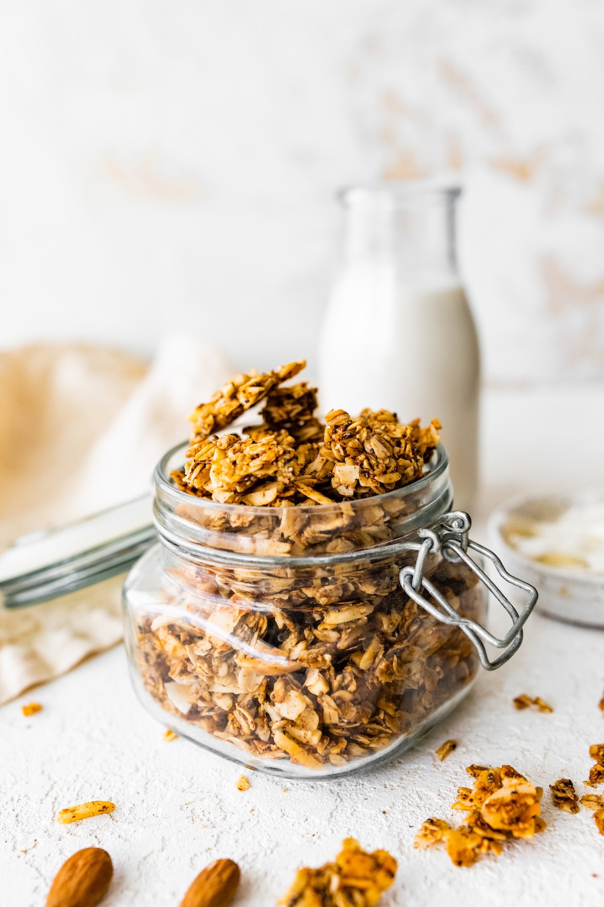 A glass jar filled to the brim with coconut granola.