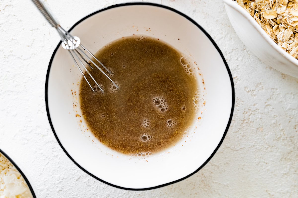 A small bowl with a metal whisk, flax seeds, and water.