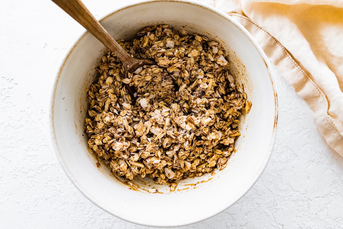 A large mixing bowl of coconut granola before being prepared in the oven.