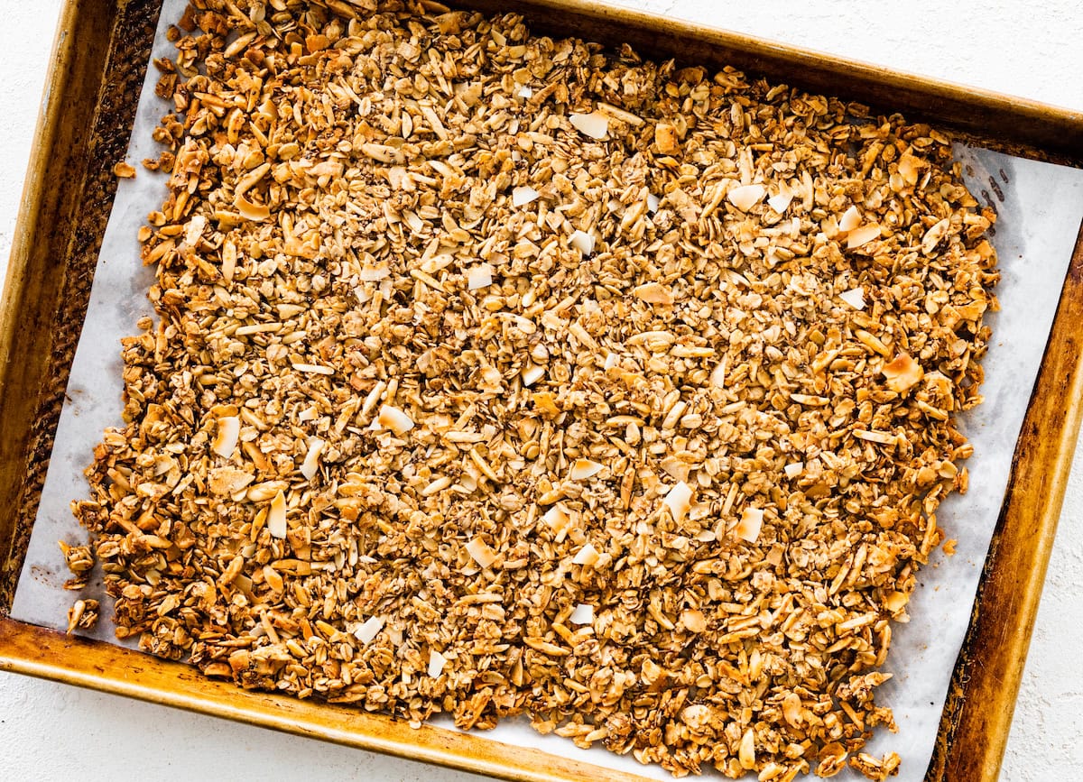 A large baking tray of coconut granola after being baked in the oven.