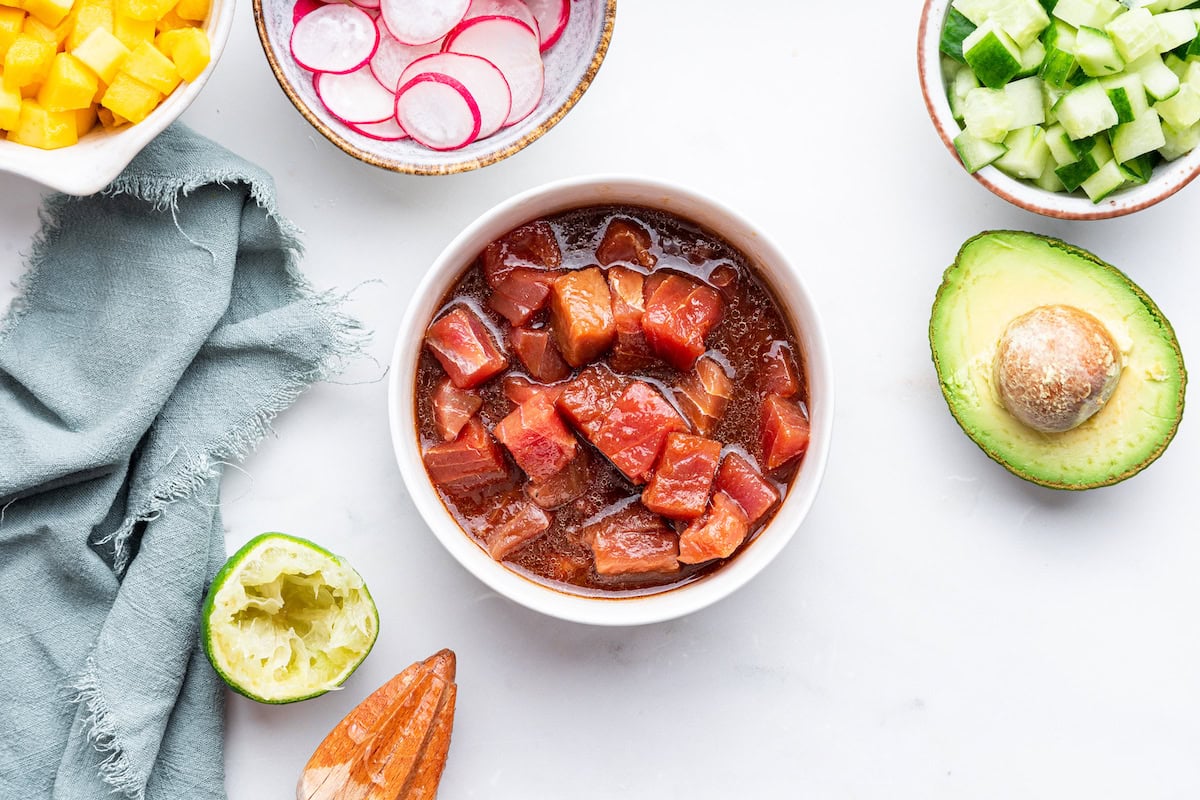 Raw tuna marinating in a small bowl.