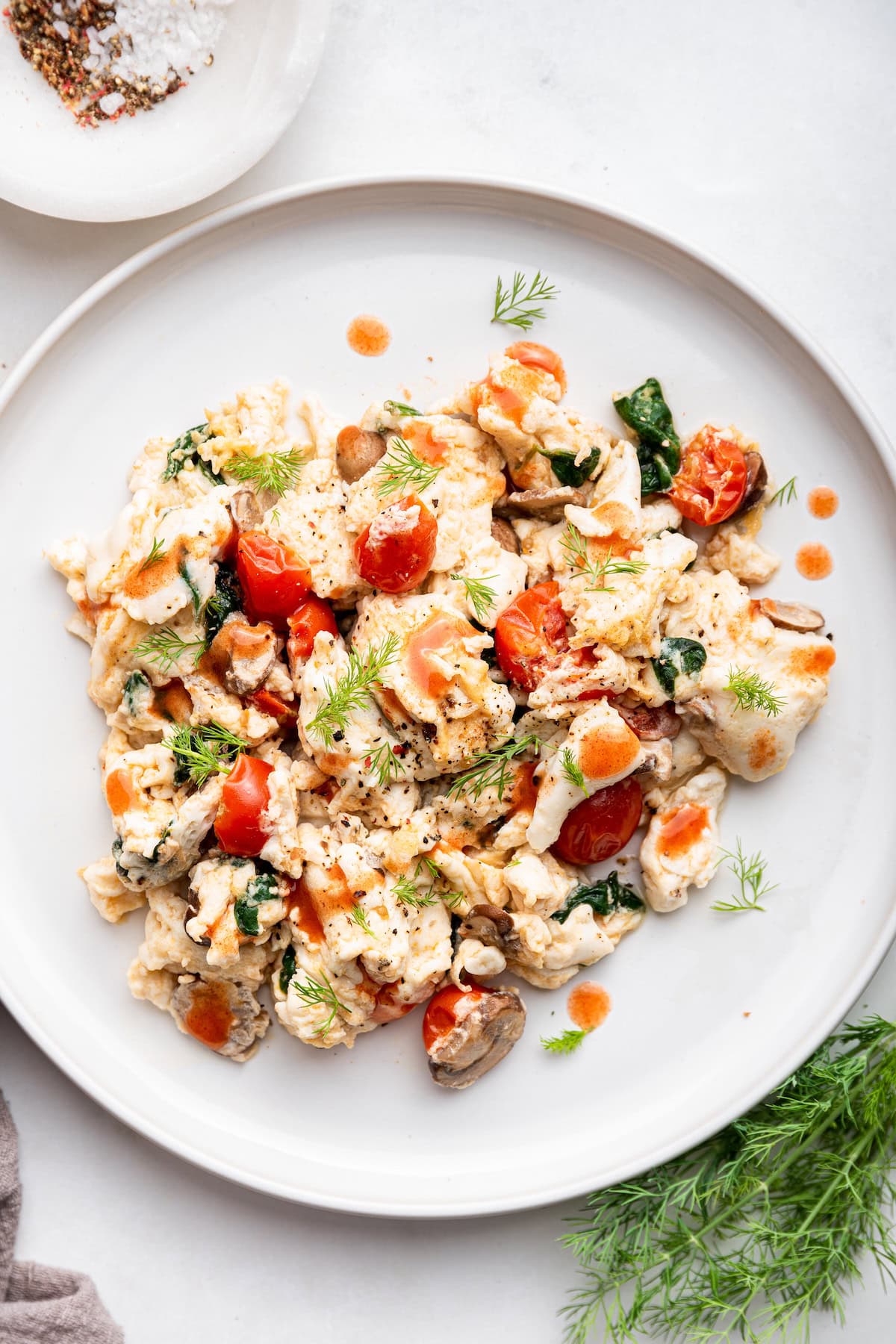 A plate of scrambled egg whites with a garnish of fresh herbs.