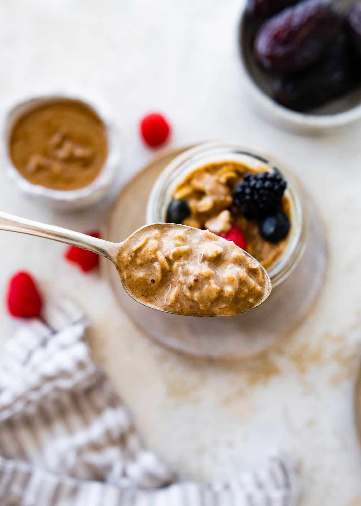 A spoonful of vanilla overnight oats held over a jar of the oats.