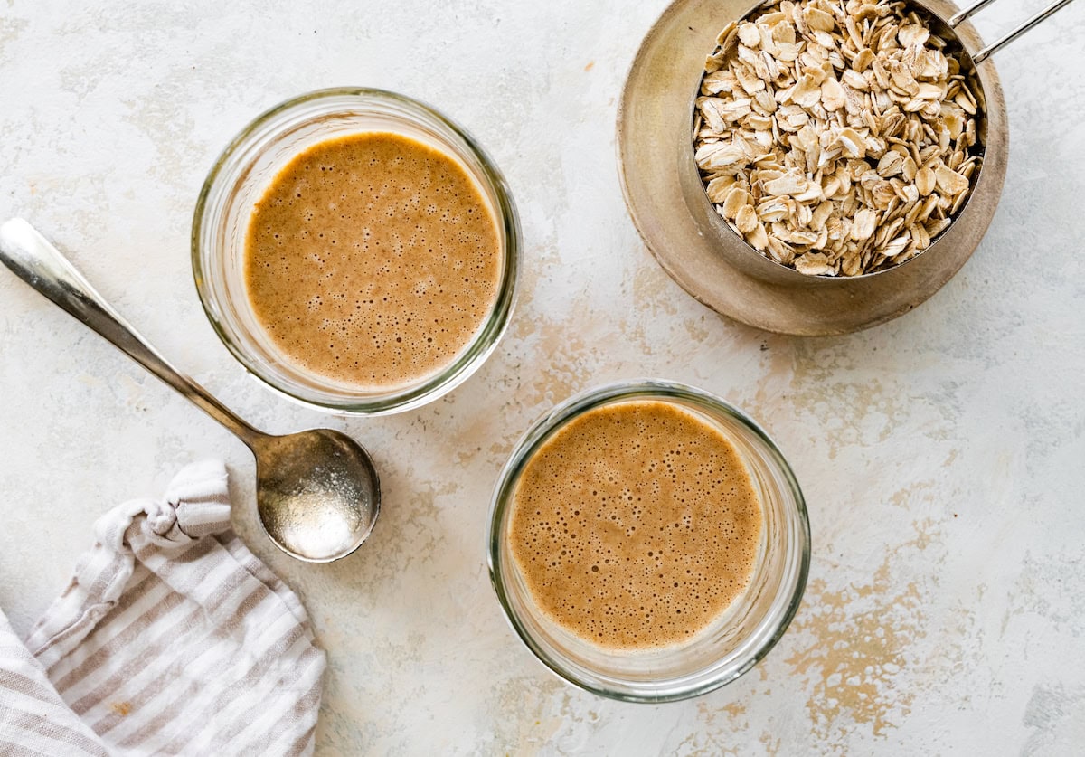 A date, almond butter, and vanilla mixture in two glass cups.