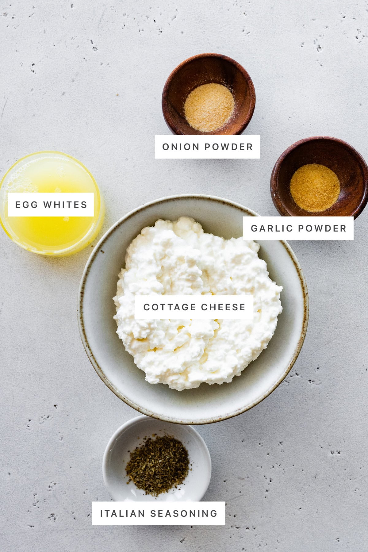 Ingredients measured out to make Cottage Cheese Wrap: onion powder, egg whites, garlic powder, cottage cheese and Italian seasoning.