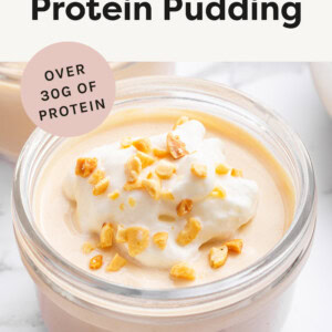 Peanut Butter Protein Pudding in a jar topped with whipped cream and chopped peanuts.