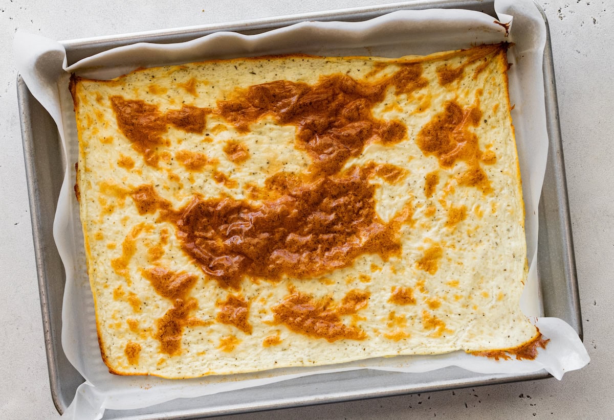 A baked cottage cheese wrap in a baking tray on parchment paper.