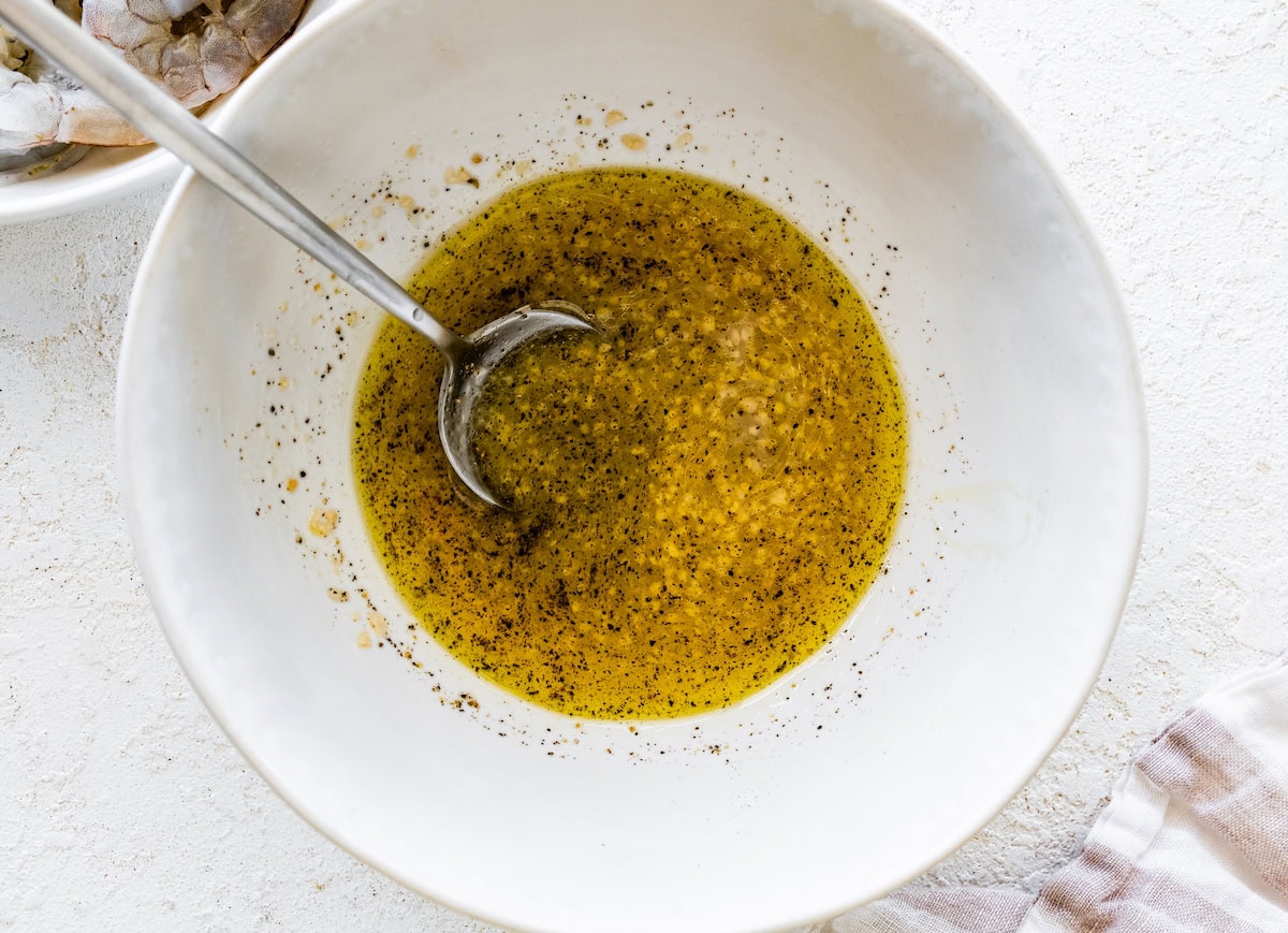garlic, lemon zest, lemon juice, oil, salt and pepper in a medium mixing bowl.
