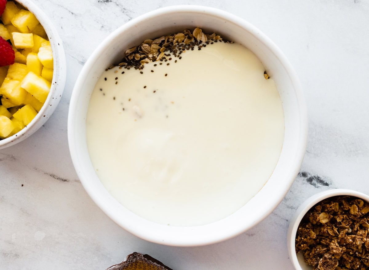 A large bowl of milk, rolled oats, chia seeds, and cinnamon.