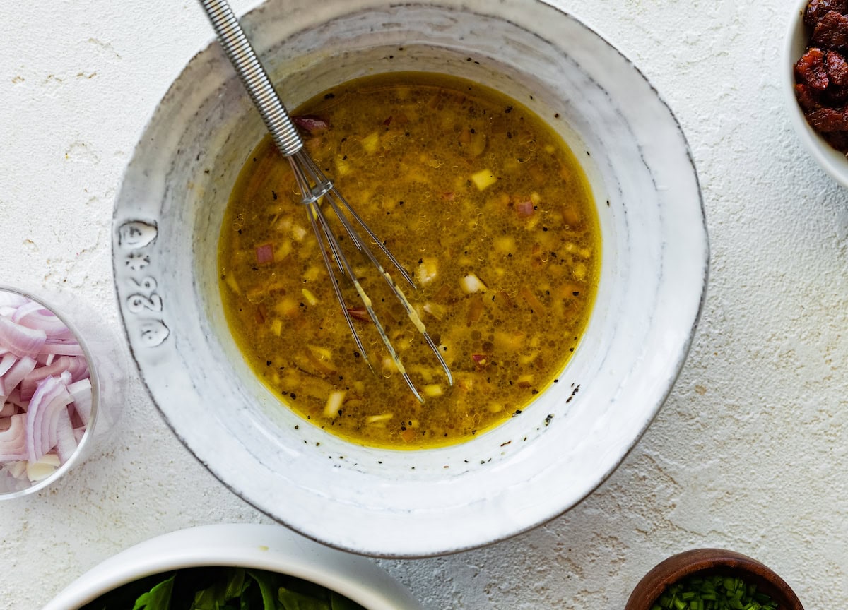 A small bowl of mustard, vinegar, and spices used for a dressing.