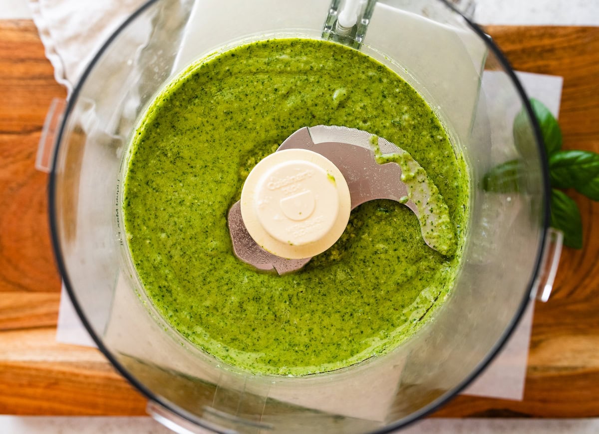 Smooth pesto in the food processor after being blended up.