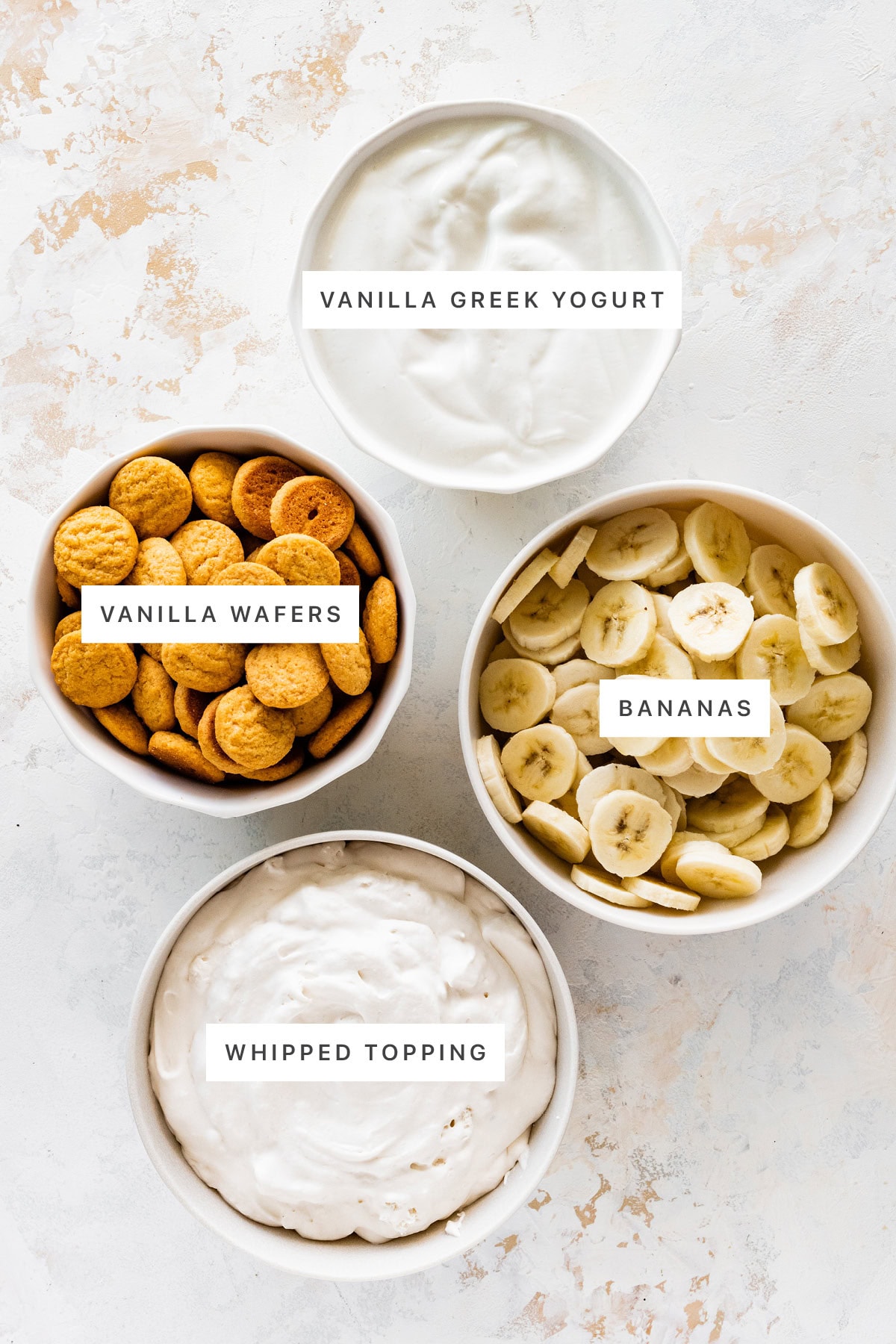 Ingredients measured out to make Healthy Banana Pudding: vanilla Greek yogurt, vanilla wafers, bananas and whipped topping.