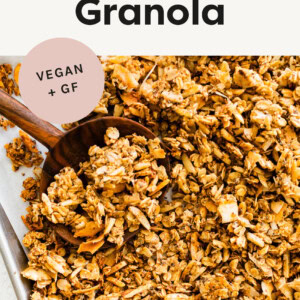 Coconut Granola on a baking sheet with a wood spoon.