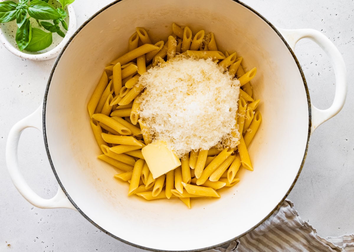 A large pot of pasta with parmesan cheese and butter.