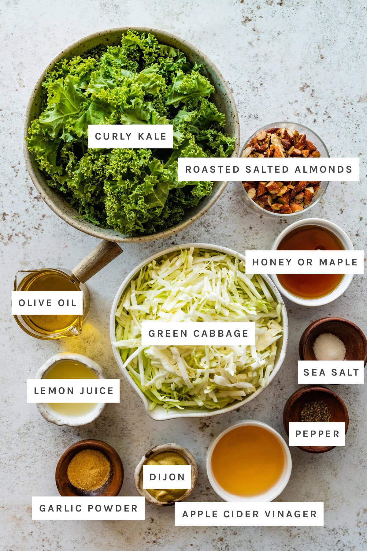 Ingredients used for chick-fil-a-kale salad include: kale, almonds, honey, green cabbage, olive oil, lemon juice, garlic powder, dijon mustard, vinegar, salt, and pepper.