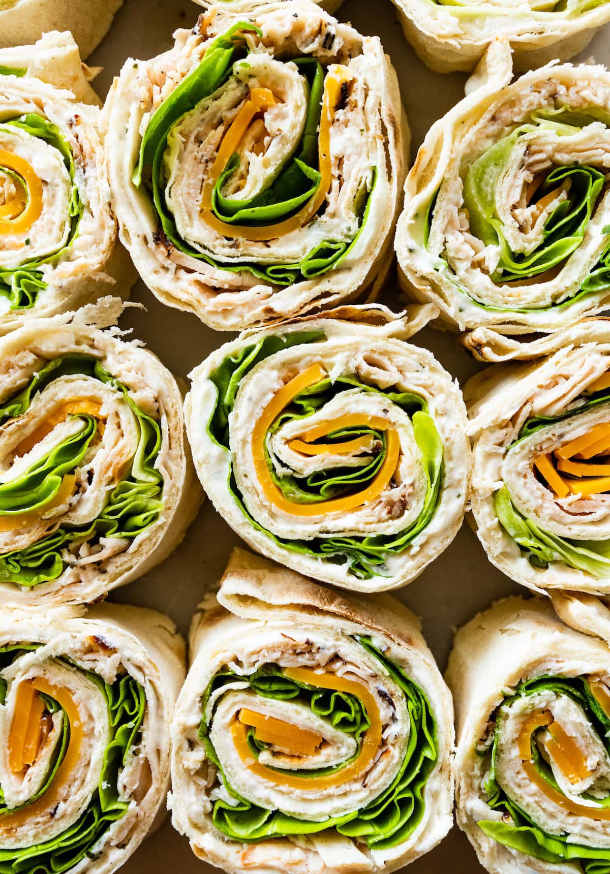 Multiple turkey pinwheel sandwiches lined up near one another.