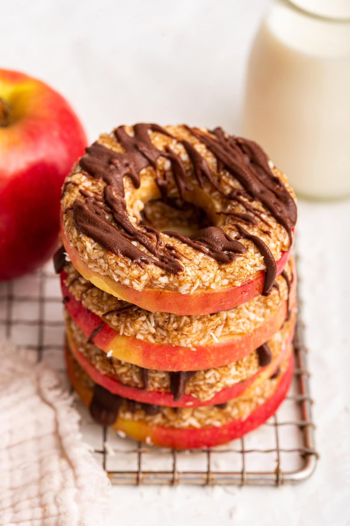 Four apple samoas stacked on one another on a cooling wire rack.