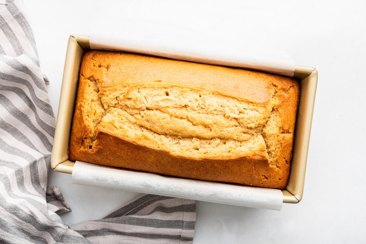 A baked loaf of french yogurt cake in a bread pan.