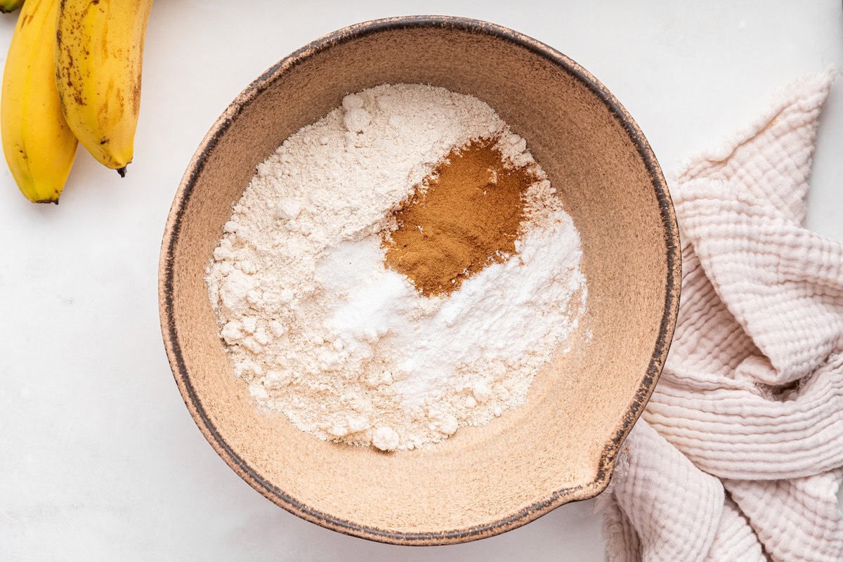 A large mixing bowl of dry ingredients used for an oat flour banana bread.
