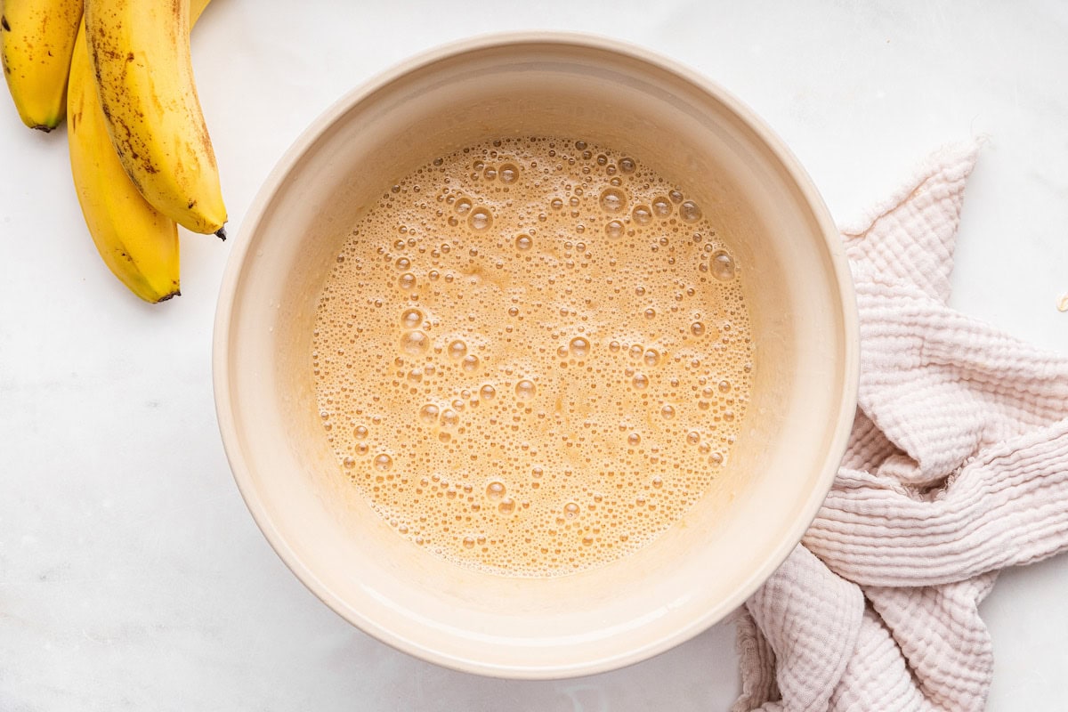 A large bowl of wet ingredients used for an oat flour banana bread.