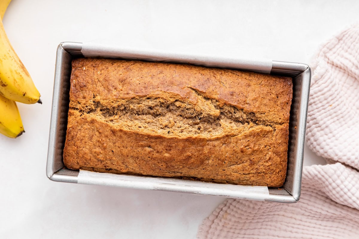 Baked oat flour banana bread cooling in a loaf pan.