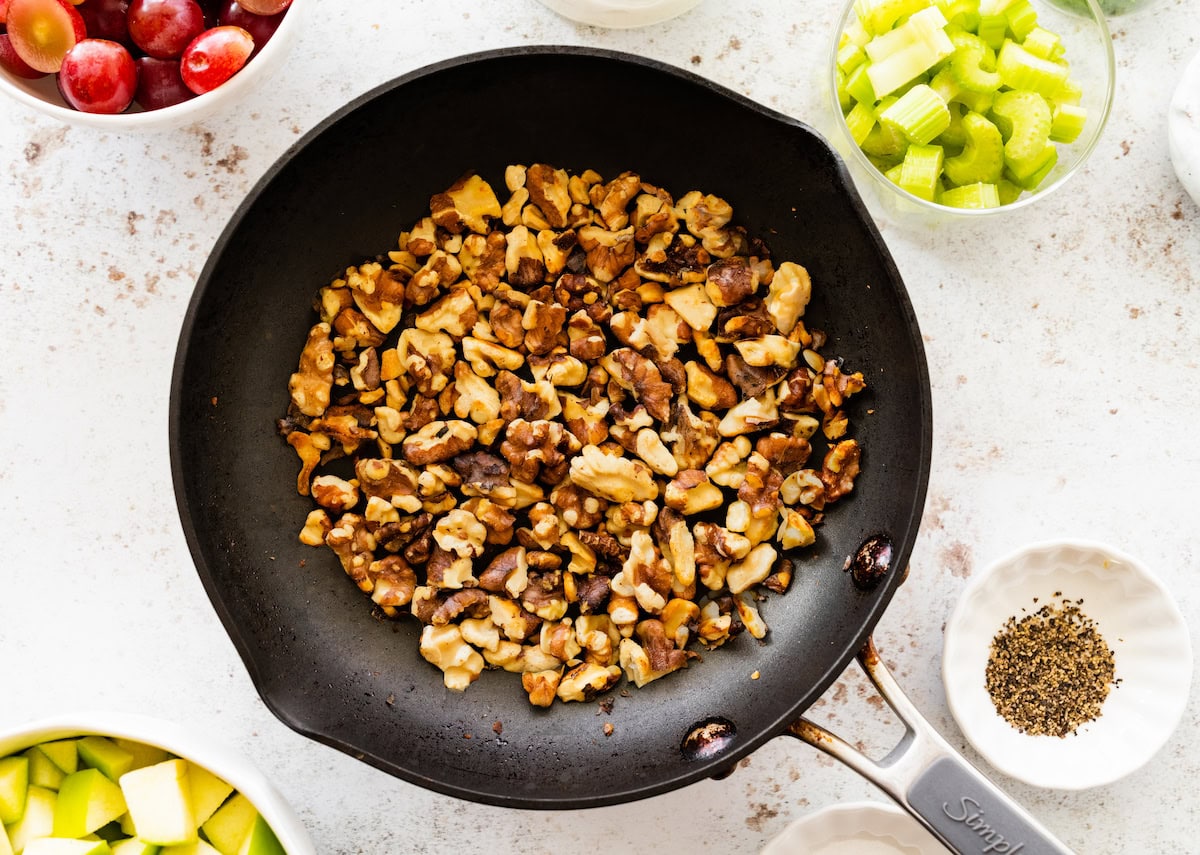 Toasted walnuts in a skillet.