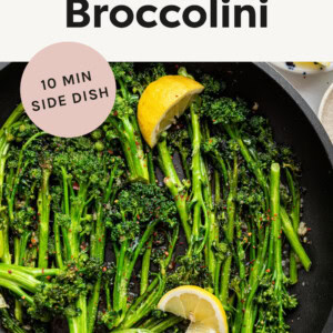 Sautéed Broccolini in a skillet topped with red pepper and lemon slices.