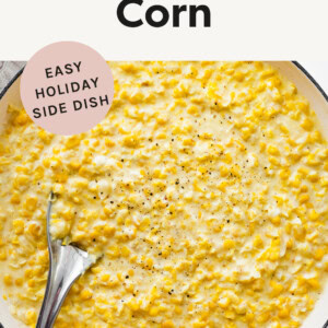 Creamed corn in a pot with a spoon.