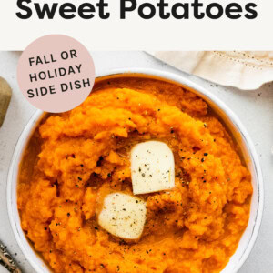 Bowl of Mashed Sweet Potatoes topped with butter and pepper.
