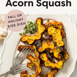 Roasted Acorn Squash on a platter with forks and fresh thume.