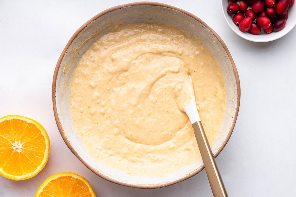 A cranberry orange muffin batter in a large mixing bowl.