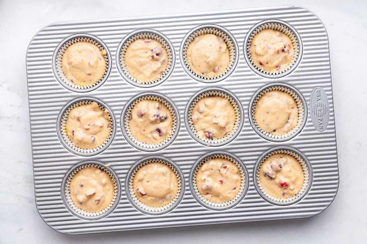 Cranberry orange muffins in a muffin tray before being baked.
