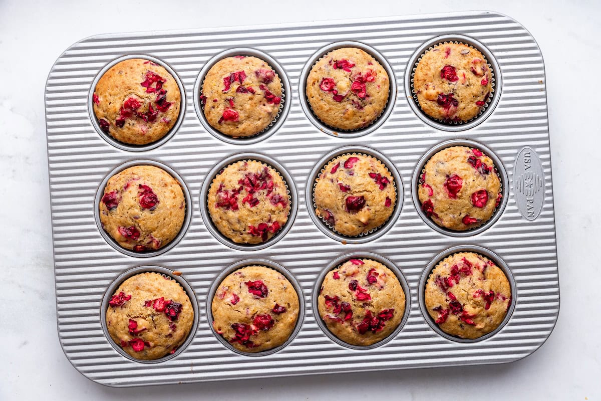 Cranberry orange muffins in a muffin tray after being baked.