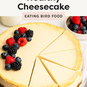 Cheesecake with slices cut, and topped with berries.