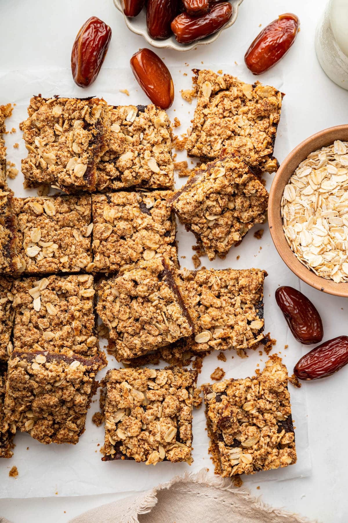 12 square date bars near one another on parchment paper.