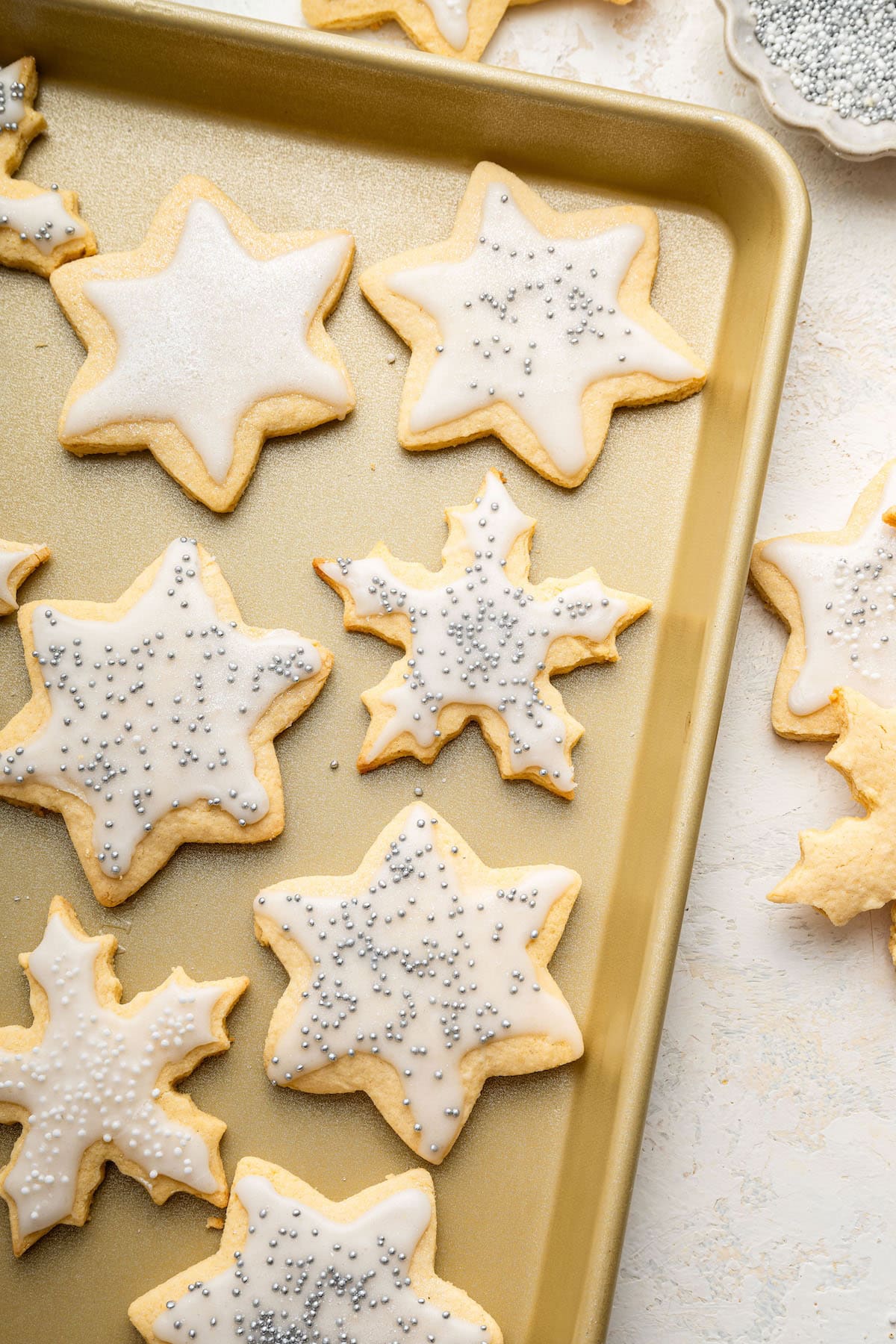 Gluten free sugar cookies Gluten free sugar cookies decorated with icing on a baking sheet.