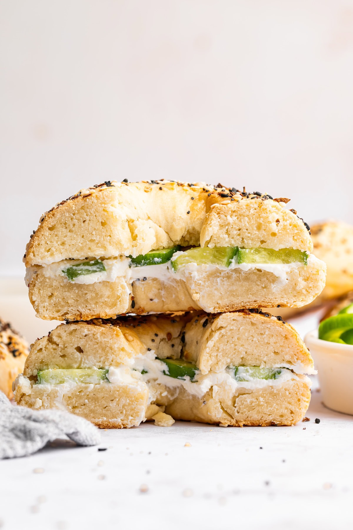 A protein bagel sandwich with cream cheese and sliced cucumber.