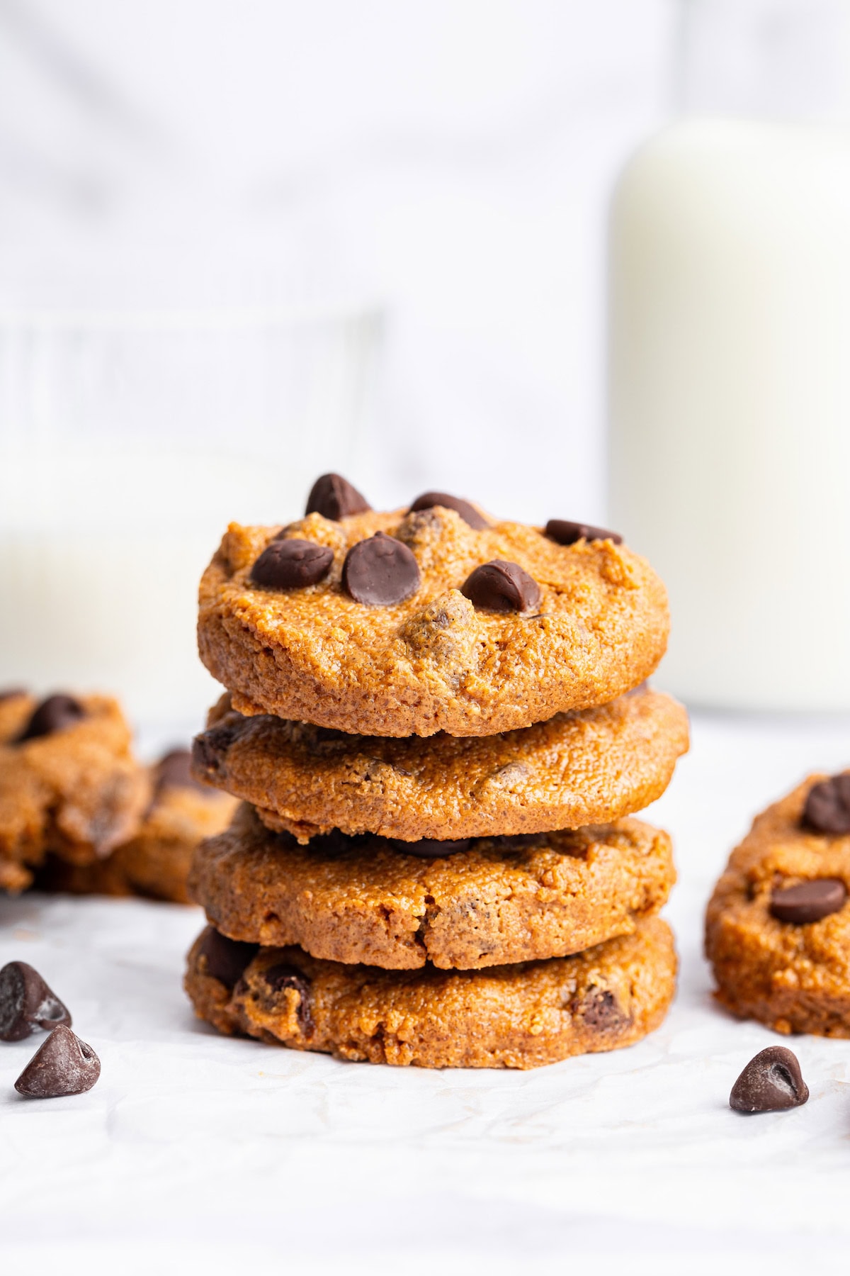 Four flourless peanut butter cookies with chocolate chips stacked on top of each other.