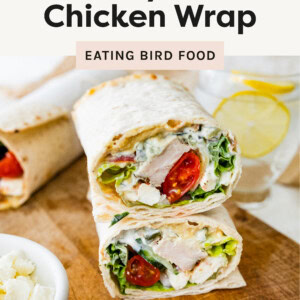 Top photo is a photo of a Greek chicken wrap cut in half! It is fresh and full of vibrant ingredients like grilled chicken, lettuce, cherry tomatoes, feta cheese, and a creamy tzatziki sauce + more all wrapped in flatbread.