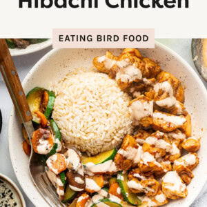 Top photo is an image featuring a hibachi-style chicken dish served in a bowl with fluffy rice, sautéed vegetables, and a drizzle of sauce. The chicken is cut into bite-sized pieces, seared to a golden brown, and coated in a flavorful sauce. The vegetables, including zucchini, carrots, mushrooms, and onions, are stir-fried to a tender-crisp texture. The rice is neatly molded into a dome shape, creating a balanced and visually appealing presentation. Surrounding elements include a glass of a bubbly beverage, a side dish with more vegetables, and small bowls of seasoning, enhancing the meal’s aesthetic and inviting appeal.