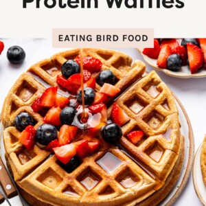 Photo of the Protein Waffles getting syrup poured on them with fruit on top.