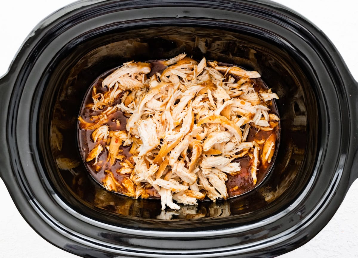 The shredded chicken in the slow cooker with the teriyaki sauce at the bottom.