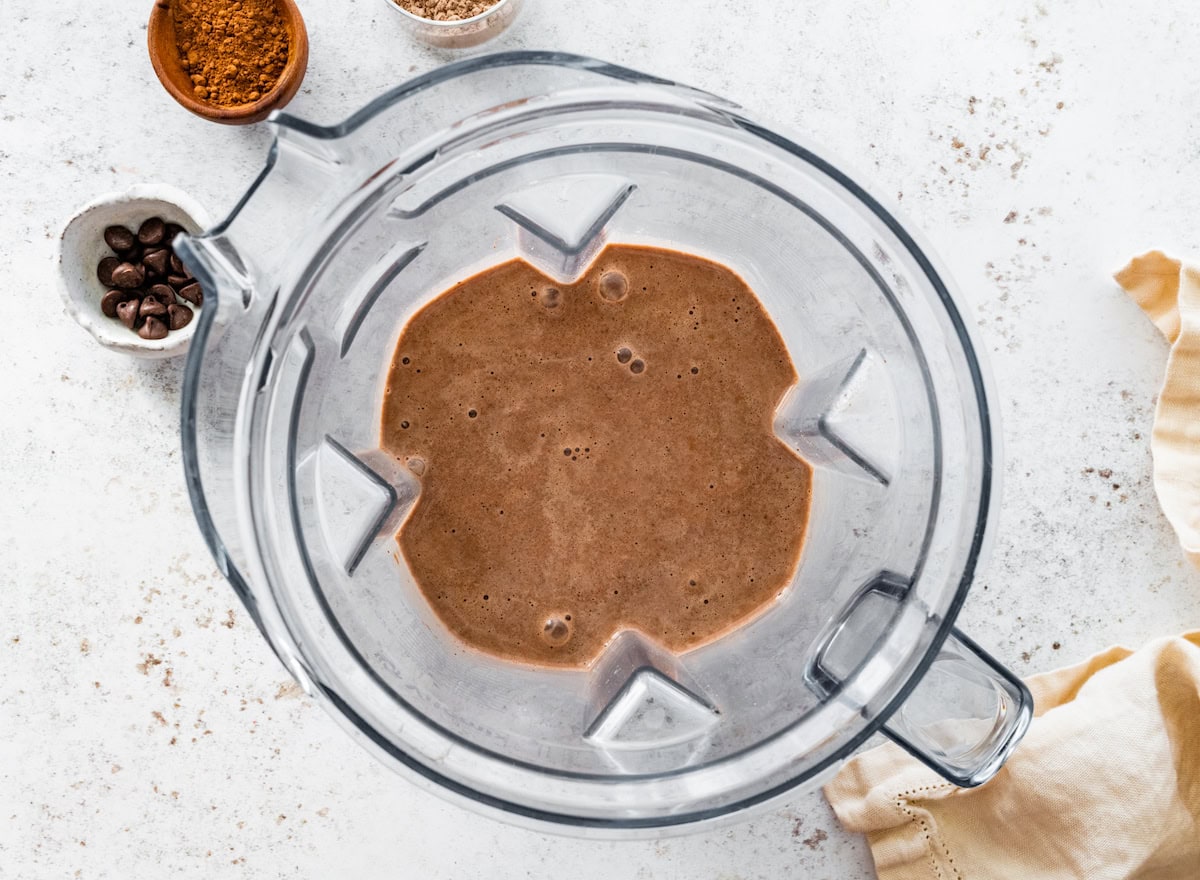 The blended thin mint protein shake in the base of a Vitamix blender.