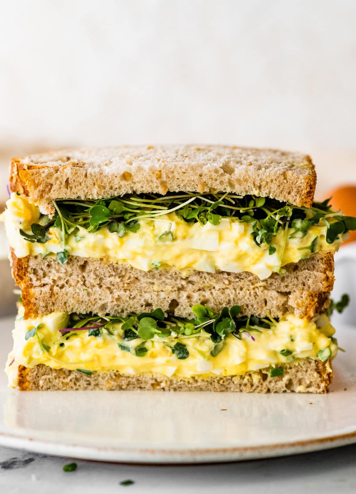 Cottage cheese egg salad served as a sandwich on whole grain bread with micro greens.