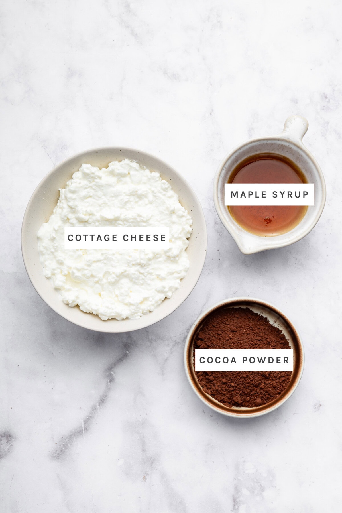 Ingredients measured out to make Cottage Cheese Chocolate Mousse: Cottage cheese, maple syrup, cocoa powder.