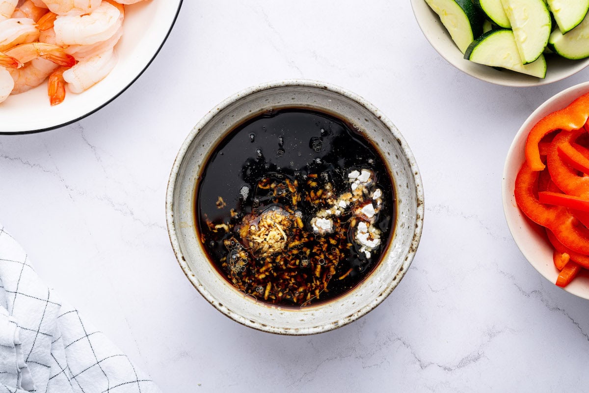 A bowl of stir-fry sauce with soy sauce, garlic, and cornstarch before being mixed.