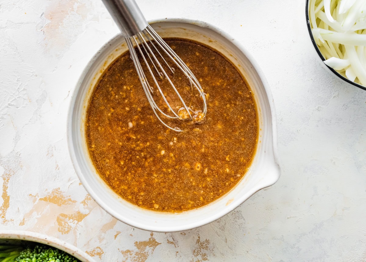 The sauce ingredients for the chicken and broccoli stir fry being whisked together in a small mixing bowl.