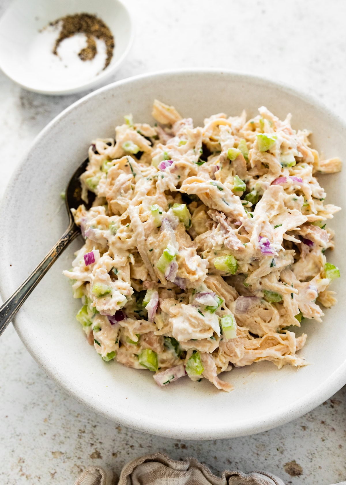 Cottage cheese chicken salad served in a white bowl with a spoon.